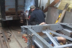 Tuesday, 5.7.2022. Adrian welds a new buffer mounting to the S&T van, as Tony relaxes while painting the chassis of waggon No. 203 ..