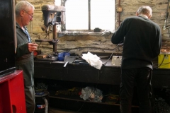 In the Engine Shed, Bob and Steve fettle up the remaining modified corner brackets for the waggon …
