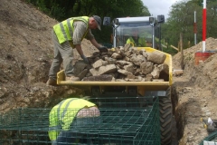 Tuesday, 12.5.2020. Access by machine to fill the baskets is getting difficult, so stone is brought down to hand pick from the dumper, Dai moving choice stones forward as Richard places them in the basket.