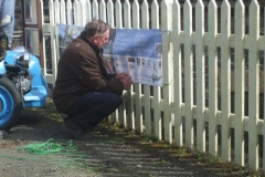 Dick secures a Dyfi Biosphere publicity banner to the roadside fence of the Engine Shed …
