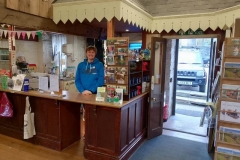 Jack "mans" the counter while Jane records the event whilst tidying the shelves and waiting for the first visitors to arrive.