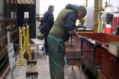 In the Carriage Shed, Ifor and Patrick drill holes in new sleepers …