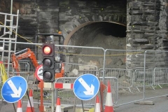 ... with daylight just visible through it and shotcreting under way to support the arch.