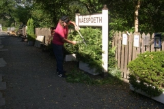 … and Richard trims around the station sign while awaiting the return of his passengers.