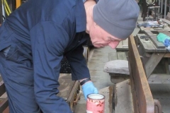 Thursday, 15.2.2024. Peter applies a priming coat to one of the platform benches within the Carriage Shed ...