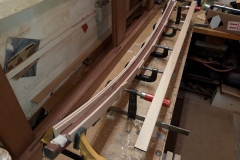 On the new build carriages the roof supports are hidden by 'U' section curved channels of meranti and in this case oak strip. Sides are clamped to the new jig.