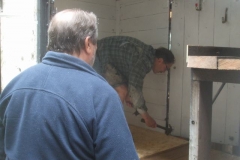 Tuesday, 24.5.2022. Bill checks on how many nails Tony is bending, as he secures a sacrificial layer of timber to the floor of the P Way van ...