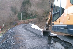 The excavator is then used to carefully excavate existing material and place it alongside the geotextile so that the whole can be rolled up to the drainage media ...