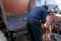 Further down the Carriage Shed, Adrian is working on the inside of some hopper bodies ...