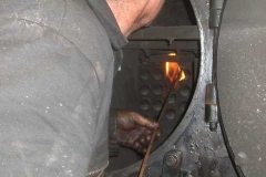 Sunday, 25.7.2021. Trefor has been called up by the loco crew to help investigate a “leak” in the smokebox of loco No. 7. Trefor is using a naked flame to try to determine the leak’s location – it is very hot in there!