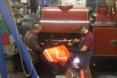 With the site barely locked up, Trefor and Jack hold up No. 7's footplate as Tony undoes the bolts on the centre support ...