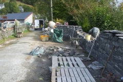 Corris Station Project. Monday, 1.10.2018. Chippin’ and assistant have resumed work on the re-located school wall – not much left to do to finish!